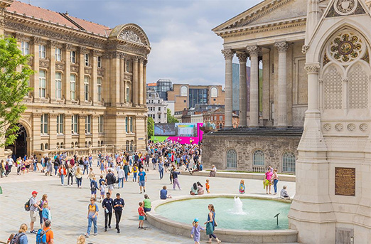 A tourist photo of Birmingham's Chamberlain Square, with the clock tower partially visible on the right.